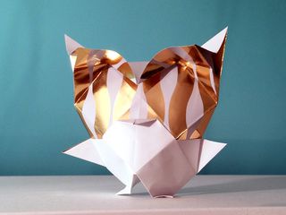 A Golden Snow Owl in Origami, folded with gift-wrapping paper