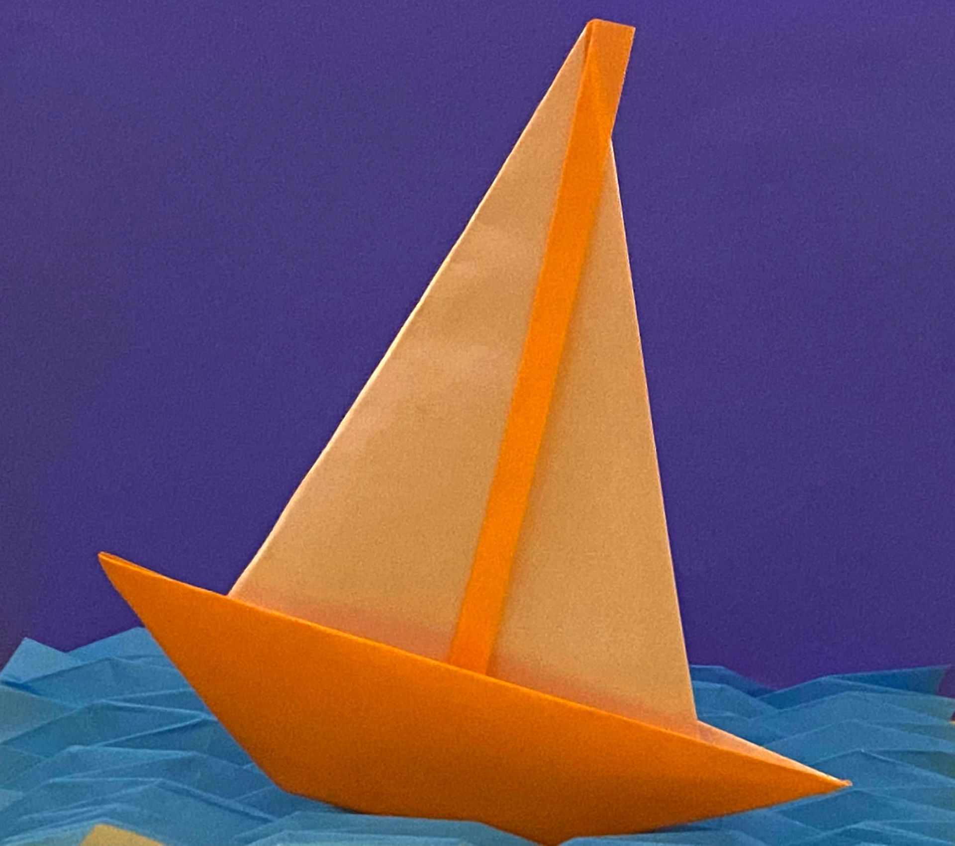 Origami boat sailing on origami waves