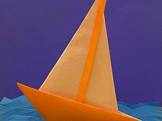 Origami boat sailing on origami waves