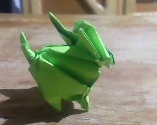 Side view of the origami kitten with its 4 legs and tail.